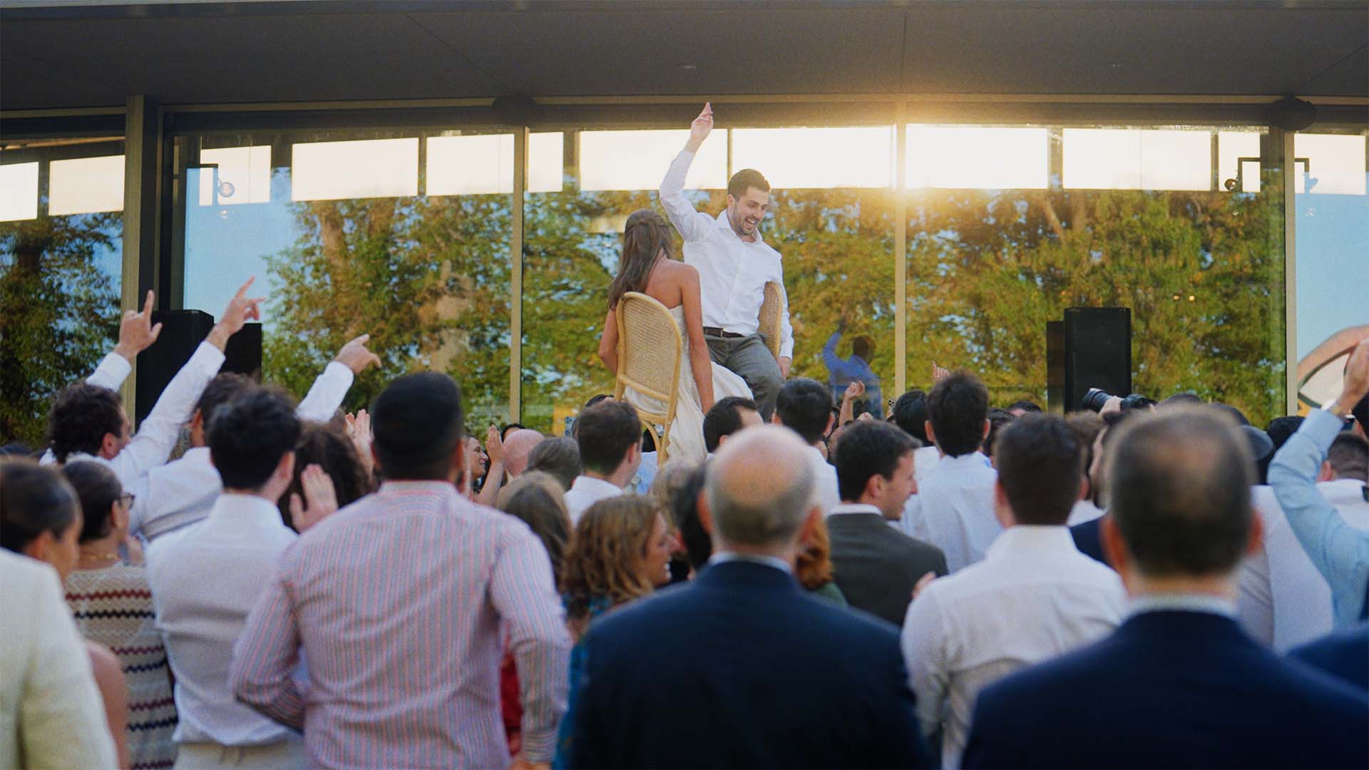 bride and groom lifted up on chairs during horas